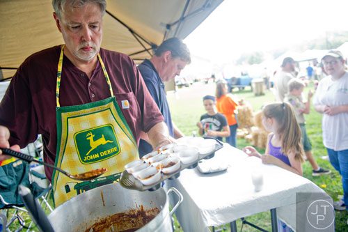 Bill Conner (left) scoops samples of chilli into cups during the 11th Annual Flowery Branch Car Show and Chili Cook Off on Saturday, September 13, 2014.