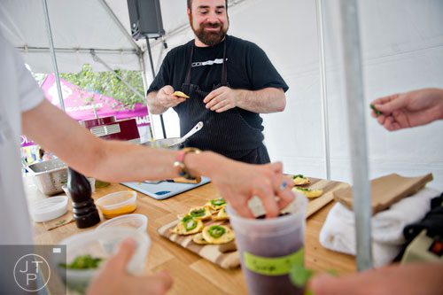 Chef Todd Ginsberg (center) gives a cooking demonstration during the Atlanta Arts Festival at Piedmont Park on Saturday, September 13, 2014. 