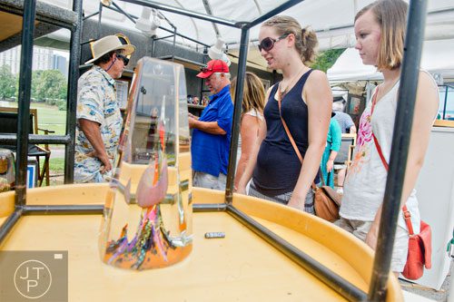 Emmaline Priger (right) and her sister Kaelin look at glass sculptures as artist Berry Davis (left) talks with Mark Clements during the Atlanta Arts Festival at Piedmont Park on Saturday, September 13, 2014. 