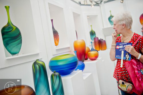 Pat Large looks at glass vases in Scott Gamble's booth during the Atlanta Arts Festival at Piedmont Park on Saturday, September 13, 2014. 