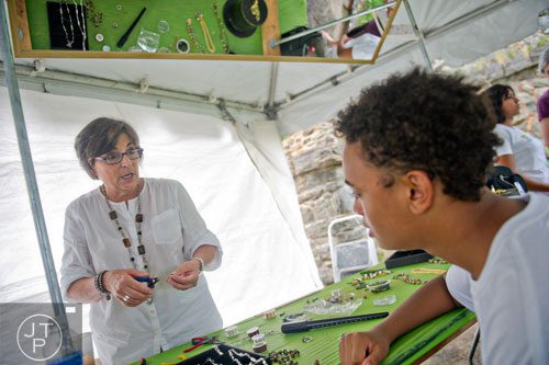 Pam Zimmermann (left) shows DeAnthony Price how to make jewelry during the Atlanta Arts Festival at Piedmont Park on Saturday, September 13, 2014. 