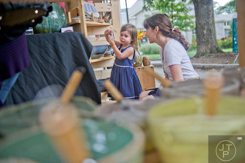 Hollis O'Neil (left) checks out different pieces of pottery made by her aunt Ester Lipscomb (right) during the Atlanta Arts Festival at Piedmont Park on Saturday, September 13, 2014. 