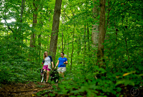 Natalie Chilcutt (left), Zoe, Katie Cochran and Coal walk the trails near the Chattahoochee River as they hike on Tuesday, August 19, 2014.