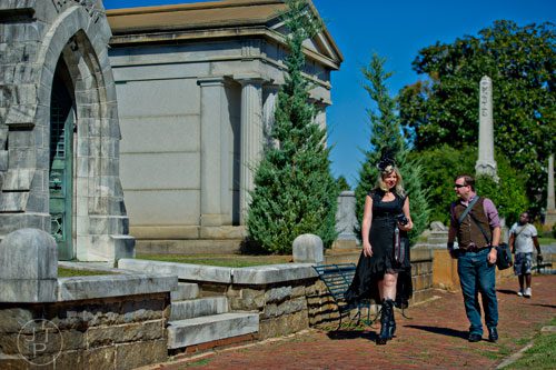 Kimberly Campbell (left) and Chris Liphart carry cameras as they walk through Oakland Cemetery in Atlanta during the 35th annual Sunday in the Park on Sunday, October 5, 2014. 
