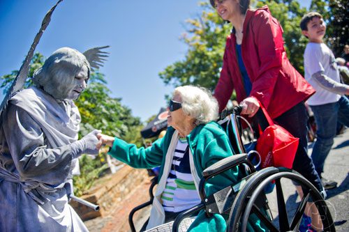Dressed as an angel, Bob Seymore (left) talks with Sara Burke and Beth Weathers at Oakland Cemetery in Atlanta during the 35th annual Sunday in the Park on Sunday, October 5, 2014.