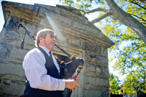 Henry Frantz plays the bagpipes in front of one of the crypts in Oakland Cemetery in Atlanta during the 35th annual Sunday in the Park on Sunday, October 5, 2014. 