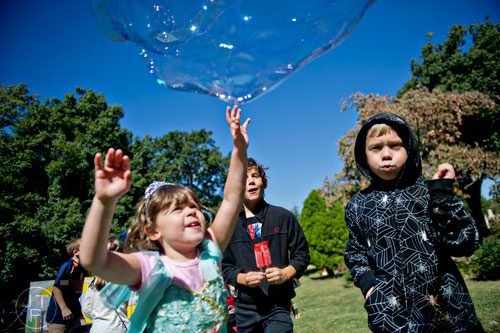 Emma Companiotte (left), Mateo Sucic and Zachary Botz try to pop bubbles in Oakland Cemetery in Atlanta during the 35th annual Sunday in the Park on Sunday, October 5, 2014. 