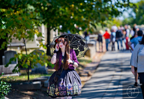 Gwynn Pollock talks on her cell phone as she walks through Oakland Cemetery in Atlanta during the 35th annual Sunday in the Park on Sunday, October 5, 2014. 