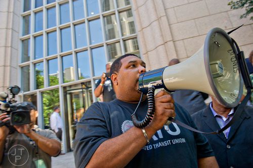 Curtis Howard (center), president of the Amalgamated Transit Union Local 732, uses a bullhorn to speak to around 150 MARTA employees and retirees as they rally in front of the law offices of MARTA Board Chair Robbie Ashe off of W. Peachtree St. in Atlanta on Monday, October 6, 2014. 