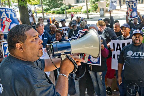 Curtis Howard (left), president of the Amalgamated Transit Union Local 732, uses a bullhorn to speak to around 150 MARTA employees and retirees as they rally in front of the law offices of MARTA Board Chair Robbie Ashe off of W. Peachtree St. in Atlanta on Monday, October 6, 2014. 