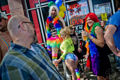 Johnny Burchett (left) and Christin Pulver (right) laugh as Tammi Flu and Josie Cuervo pose for a photo as they wait for the start of the Atlanta Pride Parade on Sunday, October 12, 2014. 