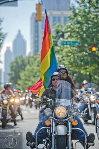Nan Ely (center) and Nicole Bryan ride Ely's motorcyle down Peachtree St. during the Atlanta Pride Parade on Sunday, October 12, 2014.