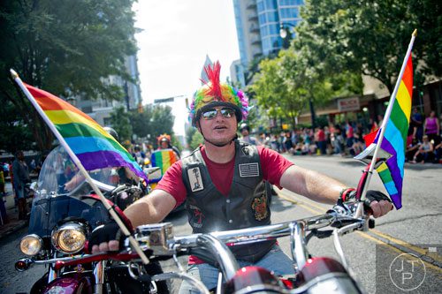 Mitch Dukes rides his motorcycle down Peachtree St. during the Atlanta Pride Parade on Sunday, October 12, 2014. 