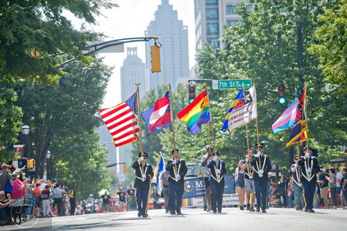 An honor guard carrying different flags leads the Atlanta Pride Parade down Peachtree St. on Sunday, October 12, 2014. 