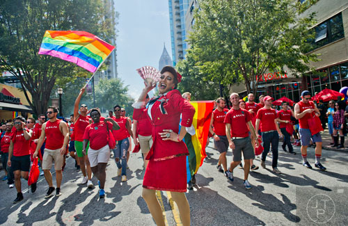 Dressed as a flight attendant, Twyla Holiday (center) marches down Peachtree St. with Delta employees during the Atlanta Pride Parade on Sunday, October 12, 2014. 