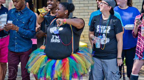 Jalicia Dunn (left) and her partner Melissa Milliron watch the Atlanta Pride Parade pass down Peachtree St. on Sunday, October 12, 2014. 