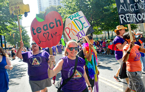 Erin Senter (center) marches down Peachtree St. during the Atlanta Pride Parade on Sunday, October 12, 2014. 