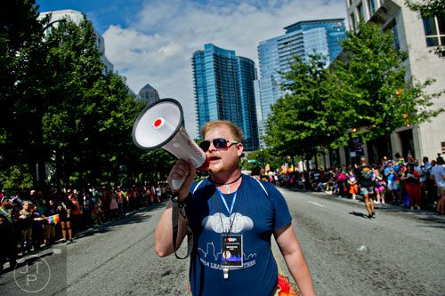 Brandon Bush uses a bullhorn to direct volunteers carrying the gigantic rainbow flag down Peachtree St. during the Atlanta Pride Parade on Sunday, October 12, 2014. 