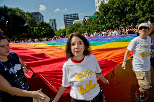 Myca Wall (center) helps carry the gigantic rainbow flag as volunteers make the turn from Peachtree St. to 10th St. during the Atlanta Pride Parade on Sunday, October 12, 2014. 