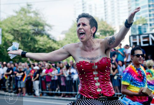 Grand Marshall Stephanie Guilloud (center) plays to the crowd as she rides a float down 10th St. during the Atlanta Pride Parade on Sunday, October 12, 2014.