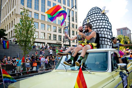 Mike Daniel (right) and Patrick Dunlea ride on the roof of a truck down 10th St. during the Atlanta Pride Parade on Sunday, October 12, 2014. 