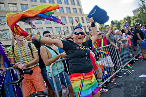 Cecilia Martinez dances in the street as she watches the Atlanta Pride Parade pass by on Sunday, October 12, 2014. 