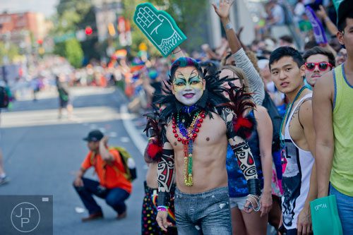 Tommy Bui (center) watches the Atlanta Pride Parade pass by on Sunday, October 12, 2014. 
