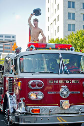 Tyler Atkinson plays to the crowd as he rides a fire truck down 10th St. during the Atlanta Pride Parade on Sunday, October 12, 2014. 