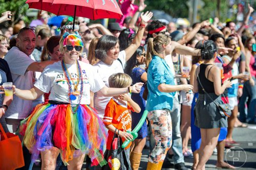 Amanda Lockhart (left) dances in the street as she watches the Atlanta Pride Parade pass by on Sunday, October 12, 2014. 