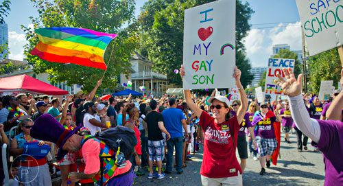 Penny McIntyre (right) holds a sign above her head as she marches down 10th St. during the Atlanta Pride Parade on Sunday, October 12, 2014. 