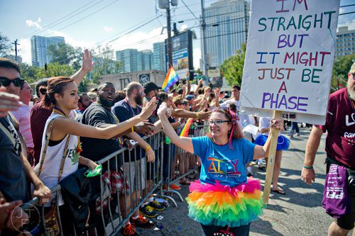 Melissa Dukes (center) gives a high five to Lauren Alfano as she marches down 10th St. during the Atlanta Pride Parade on Sunday, October 12, 2014. 