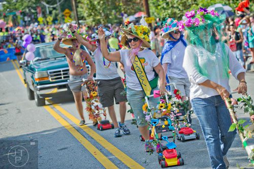 Cathy Case (center) pushes a toy lawn mower as she marches down 10th St. during the Atlanta Pride Parade on Sunday, October 12, 2014. 