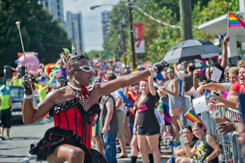 Baton Bob (left) plays to the crowd as he marches down 10th St. during the Atlanta Pride Parade on Sunday, October 12, 2014. 
