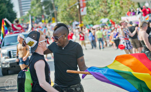 Skyler Musgrove (left) runs out to hug Kai Hudson as she marches down 10th St. during the Atlanta Pride Parade on Sunday, October 12, 2014.