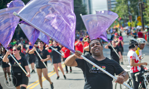 Brandon Gray (right) twirls a flag as he marches down 10th St. during the Atlanta Pride Parade on Sunday, October 12, 2014. 