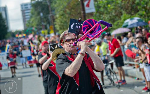 Cason Duke (center) plays the trombone as he marches down 10th St. during the Atlanta Pride Parade on Sunday, October 12, 2014. 