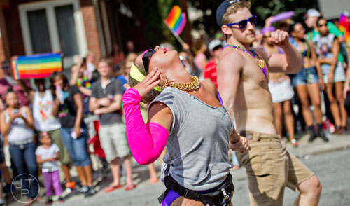 Erica Connelly (left) and Drew Duckworth dance their way down 10th St. during the Atlanta Pride Parade on Sunday, October 12, 2014. 