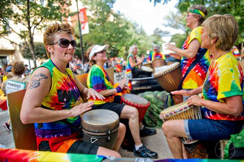 Roberta Markevitch (left) beats on a drum as she rides down 10th St. during the Atlanta Pride Parade on Sunday, October 12, 2014. 