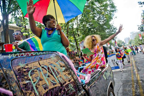 Necaela Penn (left) and Cheryl Courtney-Evans wave to the crowd as they ride down 10th St. in the back of a truck during the Atlanta Pride Parade on Sunday, October 12, 2014. 