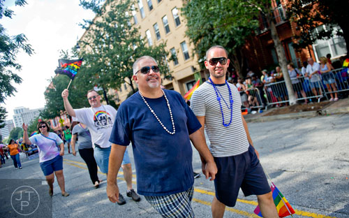 Tim Miller (left) holds hands with his partner as they march down 10th St. during the Atlanta Pride Parade on Sunday, October 12, 2014. 