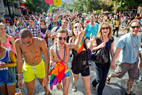 Darby Woodling (center left) and Jessie St. George (center right) follow the end of the Atlanta Pride Parade as they walk down 10th St. in Atlanta on Sunday, October 12, 2014. 