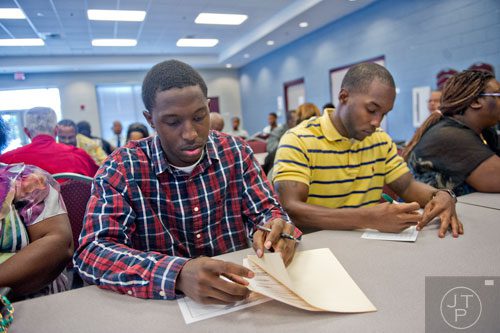 C.J. Carr (left) and Owen High fill out paperwork as they wait with other hopeful applicants for the start of the South Clayton Job Fair at the South Clayton Recreation Center in Hampton on Tuesday, September 30, 2014. 