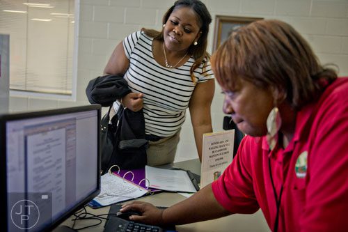 Ebonie Moore (left) gets help printing a few extra copies of her resume from Anita Davis before the start of the South Clayton Job Fair at the South Clayton Recreation Center in Hampton on Tuesday, September 30, 2014. 