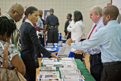 Shannetta Drake (left) takes employment information from Bill Bexley and Joel Alexis as she attends the South Clayton Job Fair at the South Clayton Recreation Center in Hampton on Tuesday, September 30, 2014.