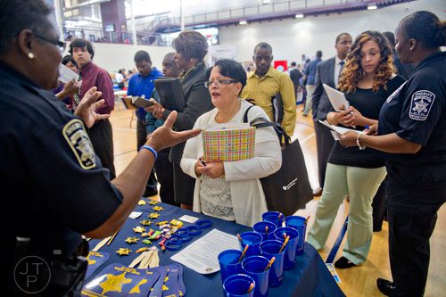 Mary Butler (center) talks with Clayton County Sheriff's Deputy Debbie Harris (left) as Kymberley Hines talks with Ofc. Tabitha Givens during the South Clayton Job Fair at the South Clayton Recreation Center in Hampton on Tuesday, September 30, 2014. 