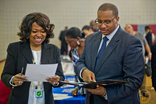 Denise Seltz (left) looks over Gerald Taylor's resume as he attends the South Clayton Job Fair at the South Clayton Recreation Center in Hampton on Tuesday, September 30, 2014. 