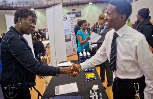 Pam Ambles (left) shakes hands with Kanod Covington as he attends the South Clayton Job Fair at the South Clayton Recreation Center in Hampton on Tuesday, September 30, 2014. 