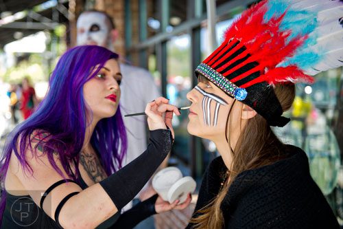 Mandy Gee (right) gets Regan Clement to apply some makeup before the start of the 14th annual Little 5 Points Halloween Parade in Atlanta on Saturday, October 18, 2014. 