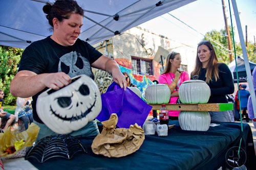 Shea Wootan (left) wraps up a piece of pottery for Savannah Harris and her mother Mandy Brown before the start of the 14th annual Little 5 Points Halloween Parade in Atlanta on Saturday, October 18, 2014. 