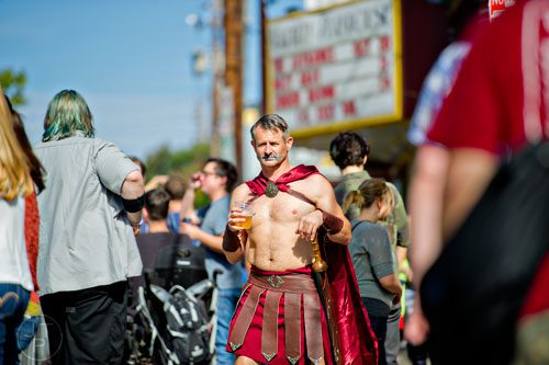 Dressed as a gladiator, Tim Riley (center) walks down Euclid Ave. before the start of the 14th annual Little 5 Points Halloween Parade in Atlanta on Saturday, October 18, 2014.